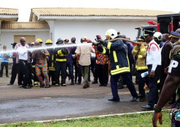 President Weah Pumps Water from the Fire hose on the grounds of the Barclay Training Center BTC.EXECUTIVE MANSION