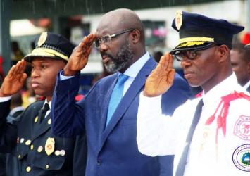 President Weah salutes along with National Fire Service Director Alex Dickson in Blue Uniform and his Deputy Gabriel Nmah at the BTC.EXECUTIVE MANSION